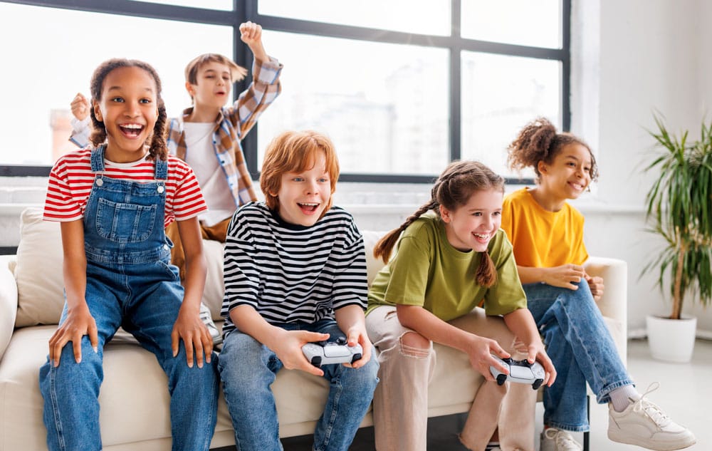 gestion-ecran Groupe d'enfant sur un canapé qui jouent à la console